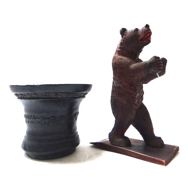 A 17th century style bronze mortar with geometric banded decoration, 16.5cm high, and a Black Forest carved wooden bear, 32cm high. (2)