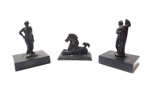 Two Victorian small bronze classical figures, each on a rectangular plinth, together with a small mythological bronze horse/dolphin on a rectangular b