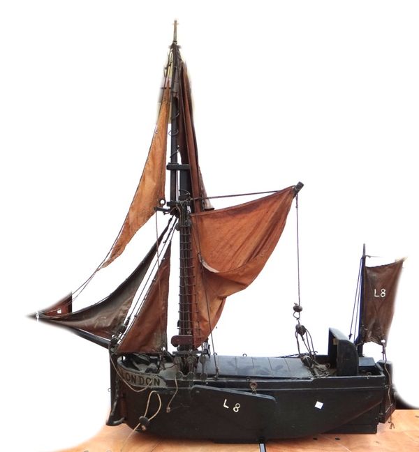 An early 20th century wooden model of a Thames barge, black painted, fully rigged and named 'London', 130cm wide.
