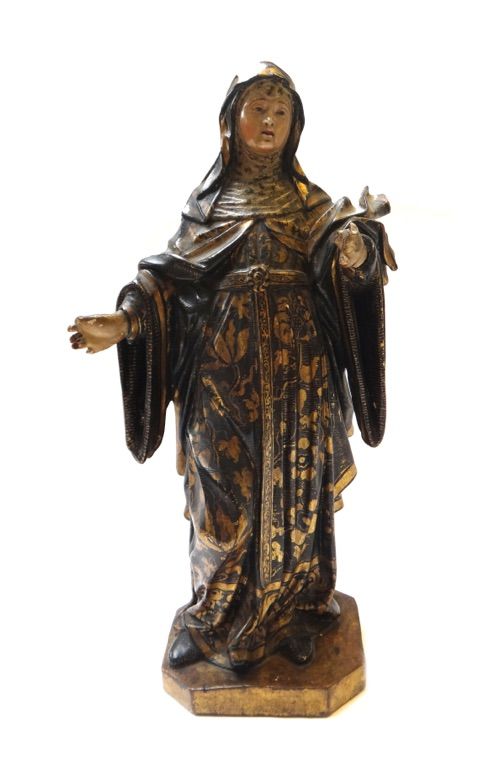 A South American softwood figure of a standing Madonna, 19th century, gilt foliate decorated against a black ground, on a canted rectangular base (a.f