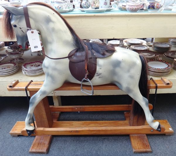 A dapple grey rocking horse on a pine swing frame base, bearing applied plaque for 'Haddon Rockers makers and restorers', 101cm high overall.