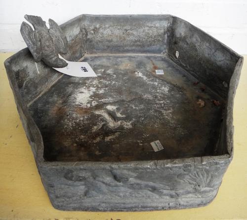 A cast lead hexagonal bird bath, with applied bird surmount and a relief cast border detailed with classical cherub figures, 42cm wide.