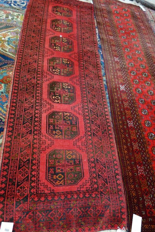 Two Afghan runners, each with a madder field, one with seven single guls, the other with many pairs of guls, multiple borders, each approx. 280 x 83cm