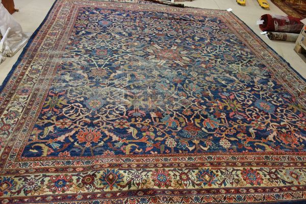 A Mahal carpet, Persian, the dark indigo field with a central flowerhead, all with abundant floral sprays, ivory flowerhead and floral spray border, 4