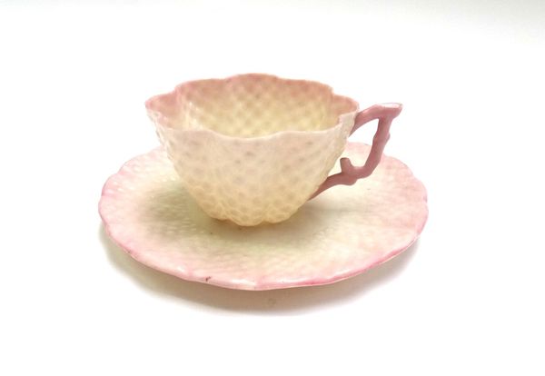 A Belleek porcelain part tea service, with black printed marks, of hob nail moulded form, with pink colouration, comprising; a teapot, a milk jug, thr