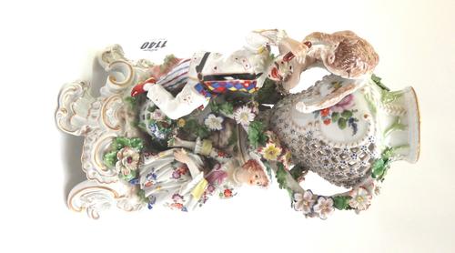 A Meissen style porcelain figural vase, early 20th century, with pierced foliate vase over a monkey, a harlequin and a young lady on a gilt scroll bas