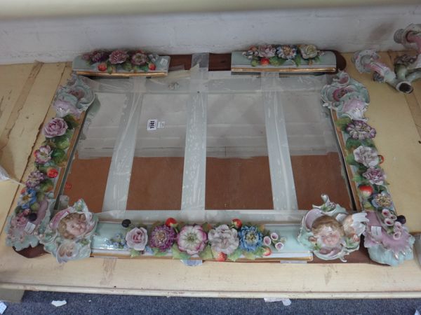 A Plaue porcelain girandole wall mirror, early 20th century, with figural surmount over an ornately floral encrusted frame issuing two three branch gi