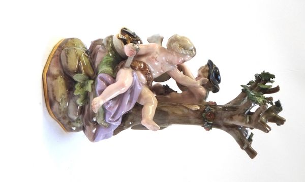 A Meissen porcelain figure group, late 19th century, with blue crossed swords marks, incised E.26, depicting Cupid sharpening his arrows on a wheel wi