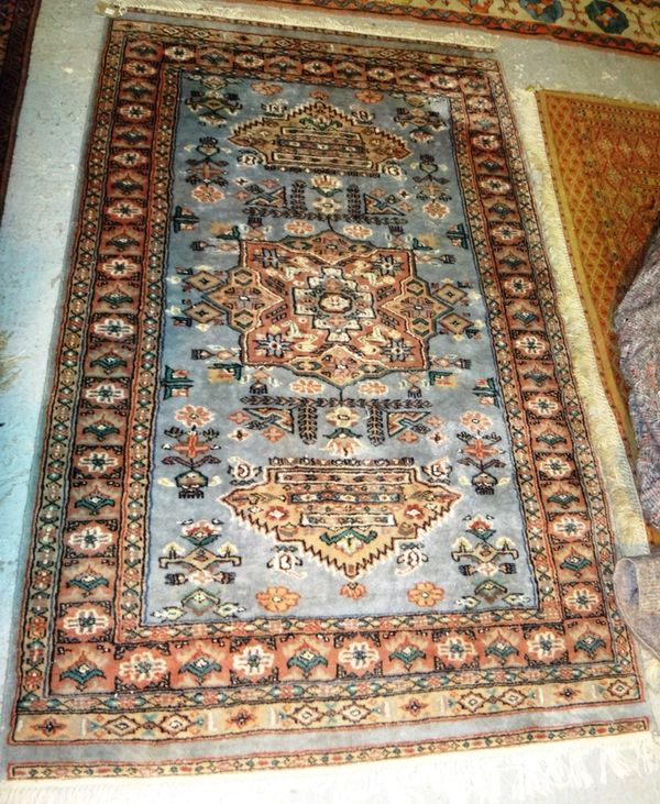 A Pakistani rug of Persian design, pale blue with a single medallion.