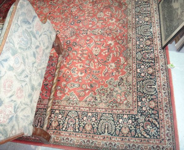 A machine made rug of Persian design, with a terracotta field.