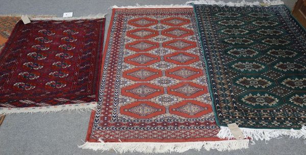 A green Pakistan rug, 150cm x 90cm, a madder Pakistan rug, 150cm x 89cm, and a Tekke Turkman rug, 110cm x 79cm. (3)