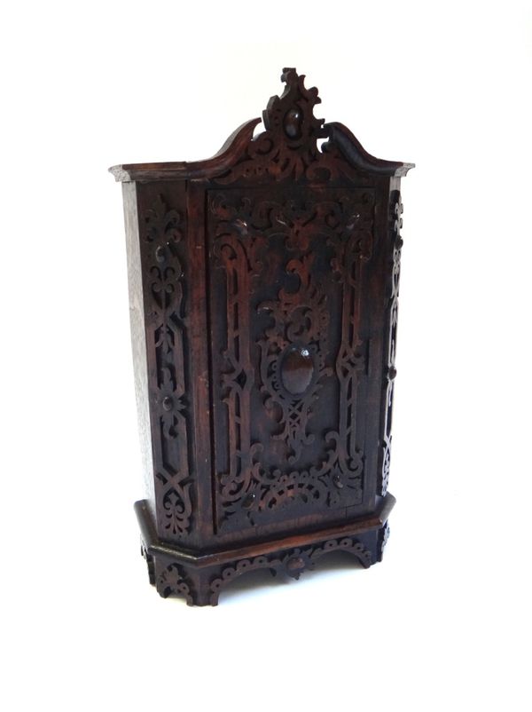 A miniature oak armoire with allover blind fret decoration and oval cabochon carved door, 31cm high.