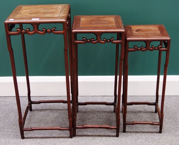 A nest of three early 20th century Chinese hardwood urn stands, with pierced and carved frieze and perimeter stretcher, the largest 29cm wide.