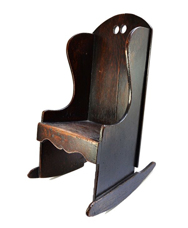 An 18th century style oak child's rocking chair of plank construction, 64cm high.  Illustrated