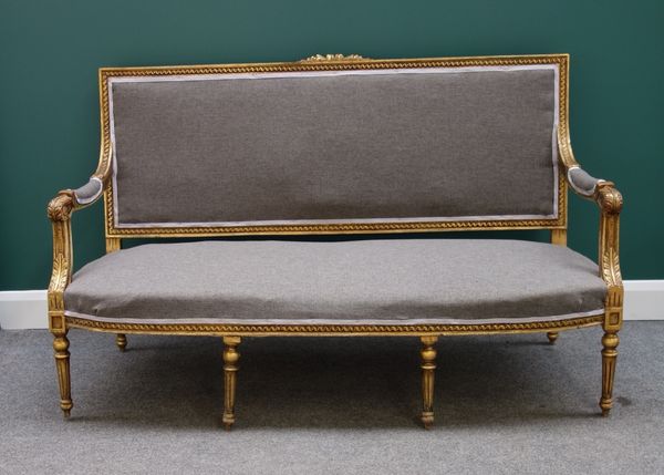 A Louis XVI style gilt canape/sofa with floral crest and open arms on tapering reeded supports, 158cm wide.