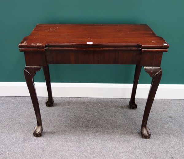 An 18th century mahogany card table, with concave top on shell capped cabriole supports and ball and claw feet, 87cm wide.