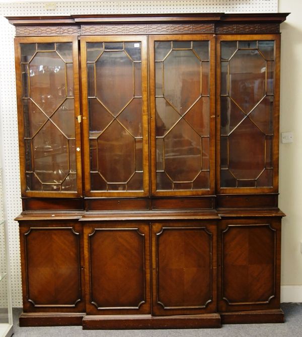 A George III style mahogany breakfront bookcase, with four astragal glazed doors over four cupboards, on plinth base, 207cm wide x 230cm high.