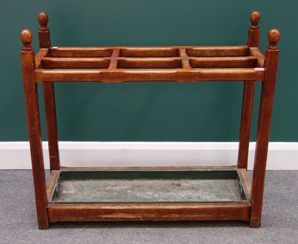 A Victorian oak four division stick stand, with ball finials and chamfered square supports, 92cm wide.