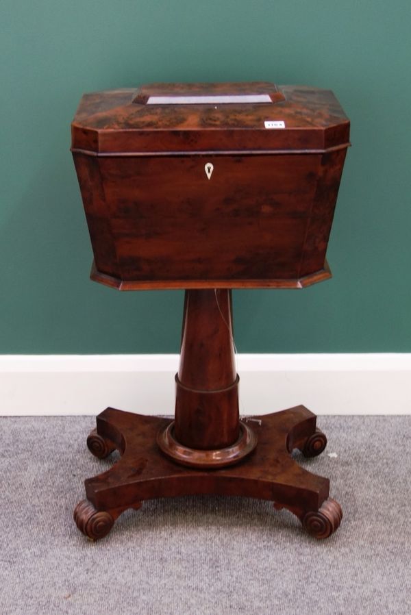 An early 19th century burr yew teapoy of canted tapering rectangular form, with four lidded interior centred by a pair of mixing bowls, on turned colu