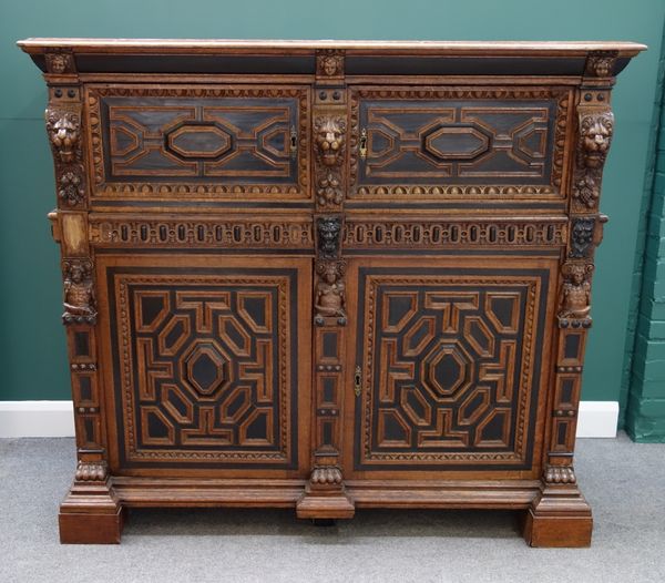 A 19th century oak and ebonised court cupboard, with two pairs of cupboards, divided by one long drawer, all with geometric moulding and lion mask mou