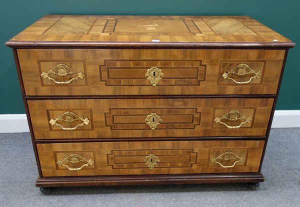 A late 18th century German parquetry inlaid gilt metal mounted three drawer commode, on bun feet, 127cm wide.