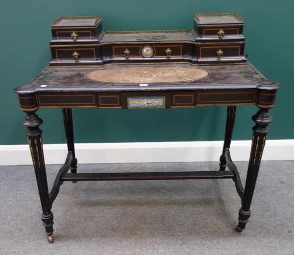 A Victorian gilt metal mounted ebonised writing desk with ceramic plaque mounts, the fitted superstructure over single frieze drawer, on out stepped t