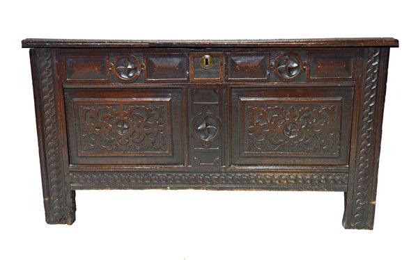 A 17th century oak coffer, the double plank top over a carved double panel front on stile feet, 111cm wide.  Illustrated