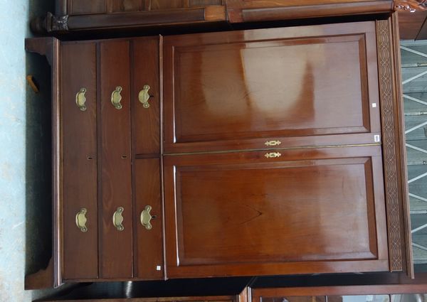 A George III mahogany linen press, the pair of panel doors enclosing four trays over two short and two long drawers, on bracket feet, 127cm wide x 188