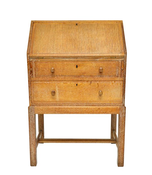 A Heals limed oak bureau, mid 20th century, the fall enclosing a fitted interior over two long drawers, on square supports united by 'H' frame stretch