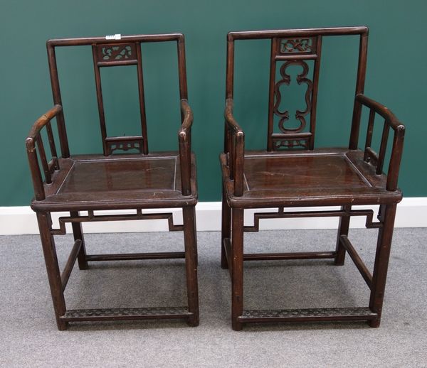 A pair of early 20th century Chinese hardwood open armchairs, with solid seats on rounded square supports.