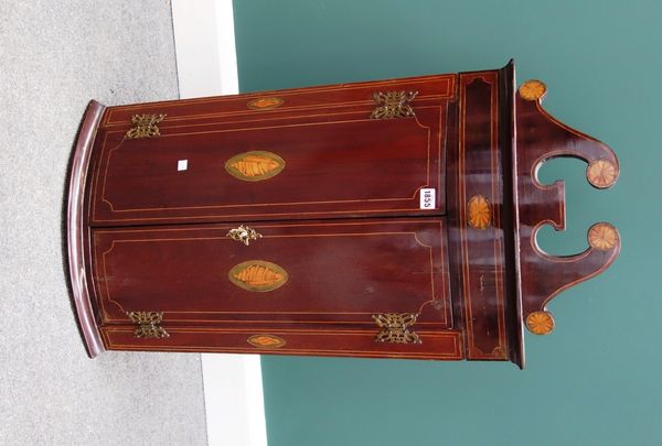 A George III mahogany hanging corner cupboard, the broken swan neck cornice over a pair of conch shell inlaid bow doors, 49cm wide.