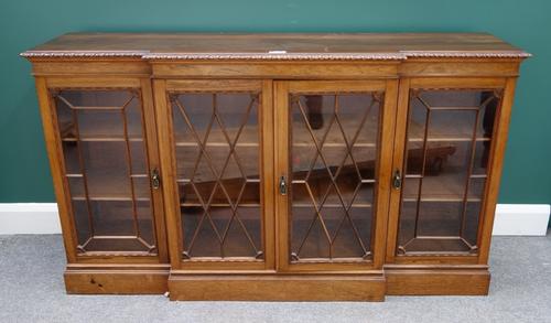A Regency style floor standing breakfront bookcase, with four astragal glazed cupboards on plinth base, 157cm wide.
