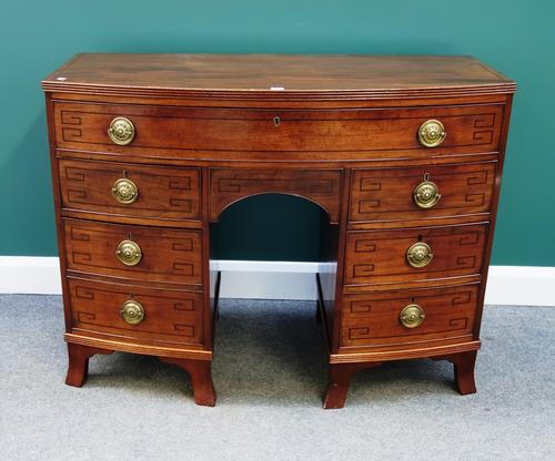 An early 19th century inlaid mahogany bowfront sideboard with one long over five short drawers, on splayed bracket feet, 122cm wide.