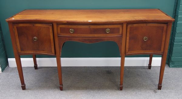 An 18th century style crossbanded and inlaid mahogany sideboard, the serpentine top over two drawers and cupboard on tapering square supports, 183cm w