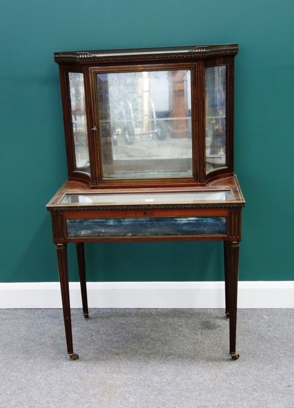 A late 19th century French brass inlaid mahogany display cabinet/bijouterie table, the galleried marble top over glazed door, flanked by swept sides,