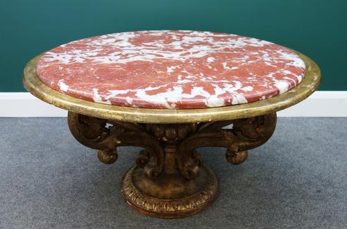 A 20th century Italian low centre table, the circular rouge marble top on four giltwood open acanthus scrolls, on a circular base, 95cm wide.