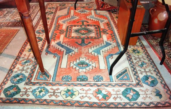 A modern Kazak rug with red field, leaf motifs and a flower border.