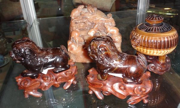 A pair of Chinese carved Tiger Eye figures of lion dogs, together with a similar lidded pot and a hardstone seal stamp.