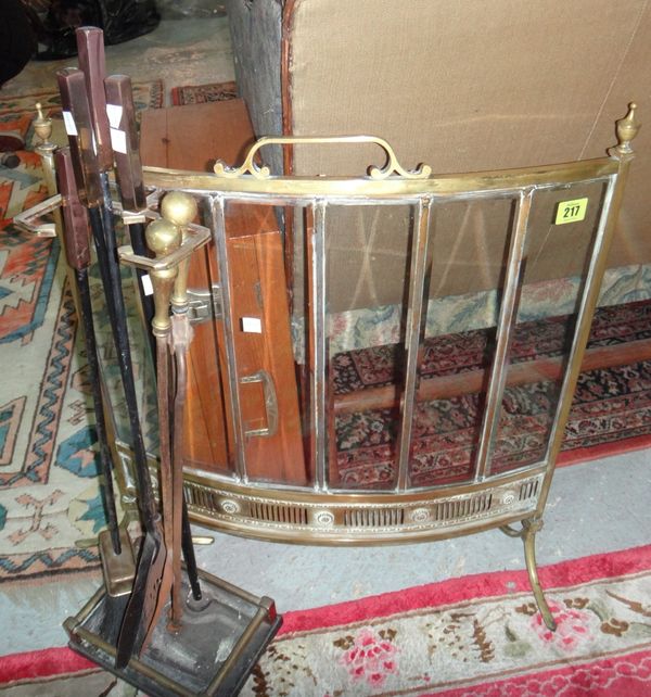 A brass and glass fire guard together with fire tools.