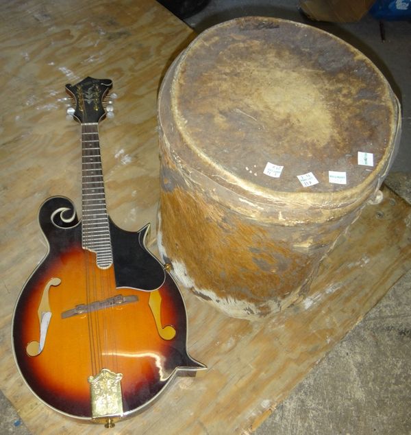 A 20th century sunburst effect mandolin, together with an animal hide drum.