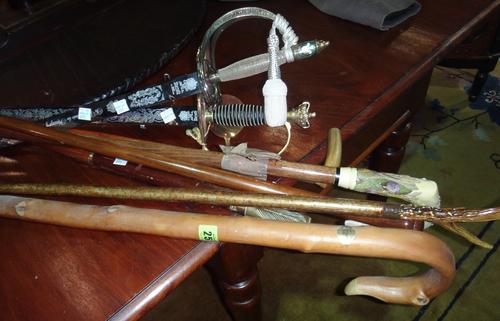 A group of 20th century walking sticks, including one with silver mounts, together with two commemorative swords.