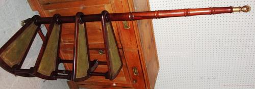 A set of mahogany and green leather spiral library steps.