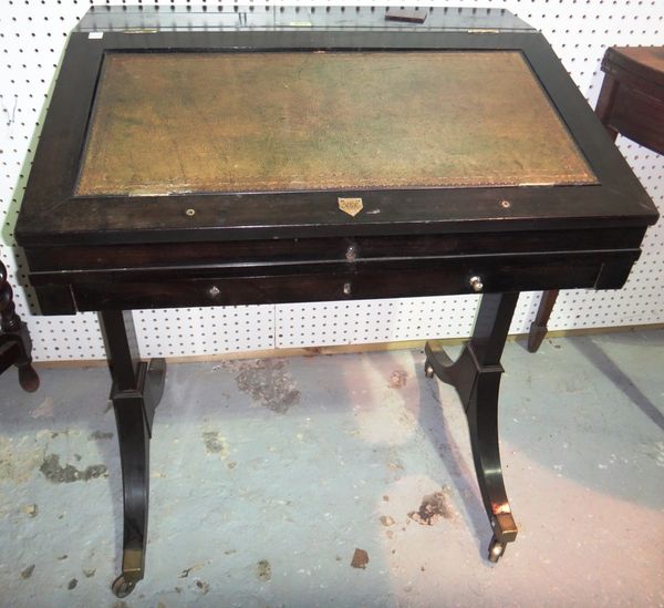 A 19th century ebonised writing table, with flip top back and angle adjustment leather surface over single frieze drawer, bearing paper label for 'Lad