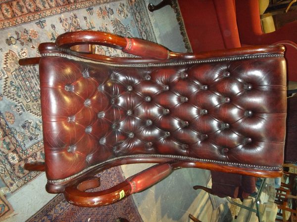 A 20th century mahogany and red leather button seated armchair.