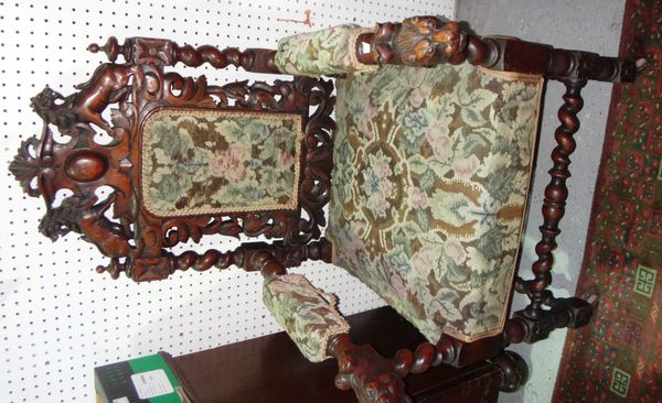 A 17th century style oak open armchair with upholstered back, seat and lions head carved arms.