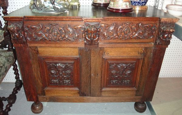 A pair of 17th century Flemish style oak side cabinets with carved panel doors and a pair of drawers.