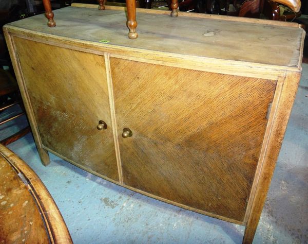 A 20th century limed oak bowfront side cabinet.