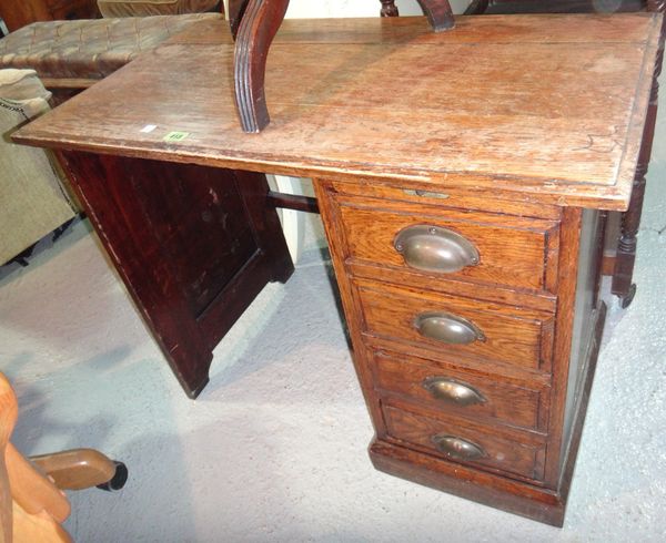An early 20th century oak desk and a low oak nursing chair. (2)