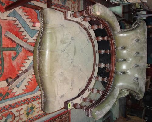 A 20th century mahogany and green leather swivel chair.