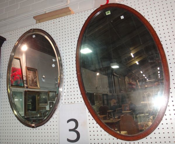 A mahogany oval wall mirror and a silver plated oval mirror. (2)